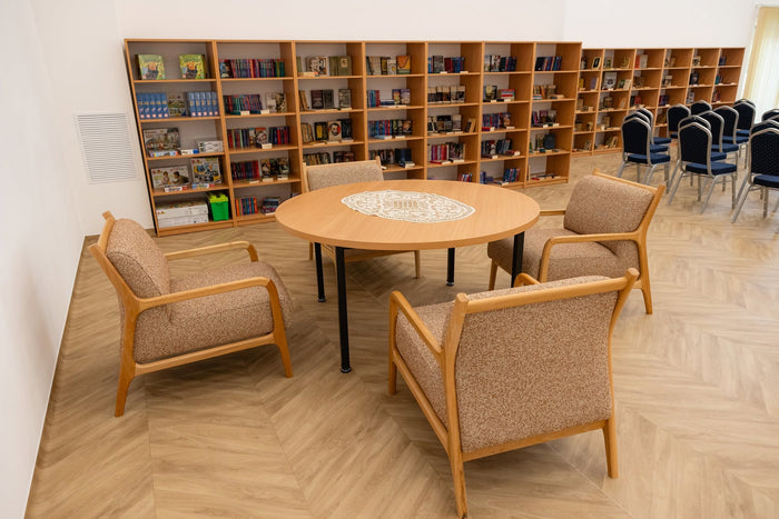 Biblioteca Căminului Sfântul Vasile din Cluj-Napoca, cu fotolii tapițate și masă rotundă de la Horeca Papatya.