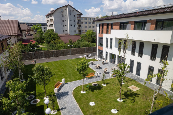 Curtea interioară și terasa Căminului de Vârstnici Sfântul Vasile din Cluj-Napoca, cu mobilier de exterior.