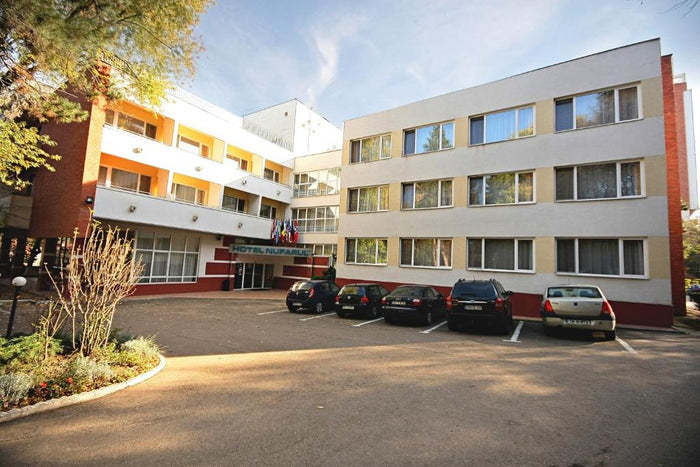 Fațada Hotel Nufărul din Băile Felix, cu firma de la intrarea principală, steaguri și parcarea din față.