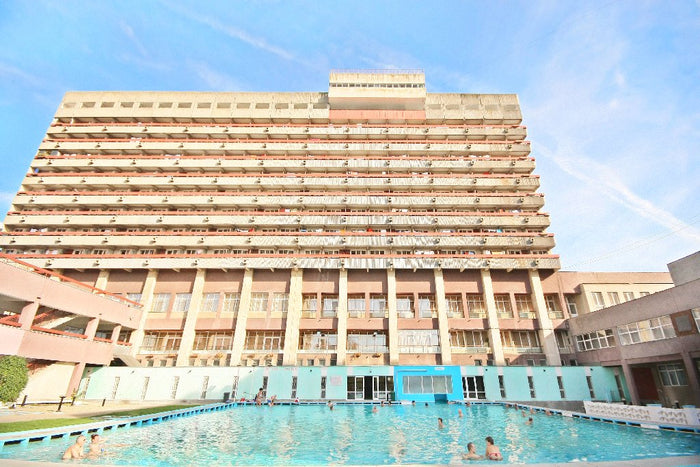Piscină exterioară în stațiunea Băile Felix, în fața unui corp de hotel cu balcoane pe mai multe etaje.