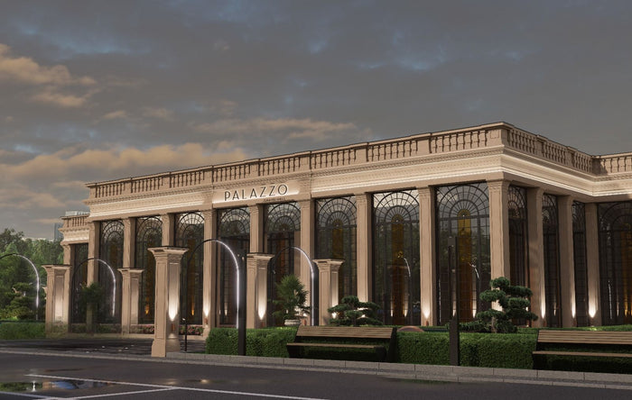 Fațada Palazzo Grand Hall Oradea seara, cu coloane iluminate, grădină cu bonsai și copaci tunși ornamental.